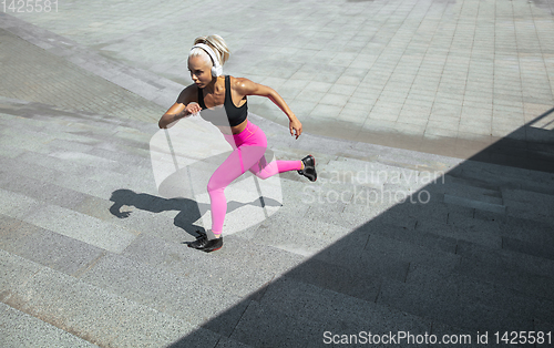 Image of A young athletic woman working out at the city\'s street