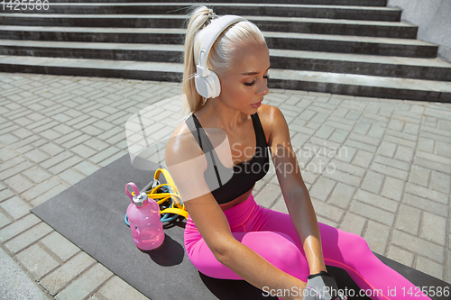 Image of A young athletic woman working out at the city\'s street