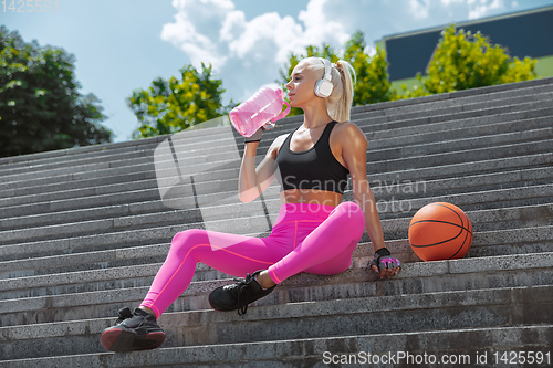 Image of A young athletic woman working out at the city\'s street