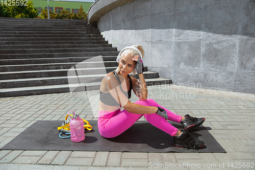 Image of A young athletic woman working out at the city\'s street