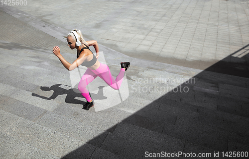 Image of A young athletic woman working out at the city\'s street