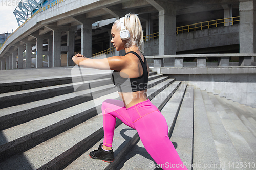 Image of A young athletic woman working out at the city\'s street
