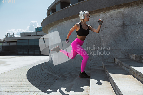 Image of A young athletic woman working out at the city\'s street