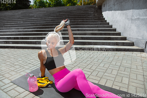 Image of A young athletic woman working out at the city\'s street