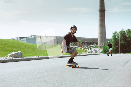 Image of Skateboarder doing a trick at the city\'s street in sunny day
