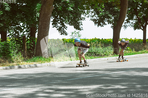 Image of Skateboarders doing a trick at the city\'s street in sunny day