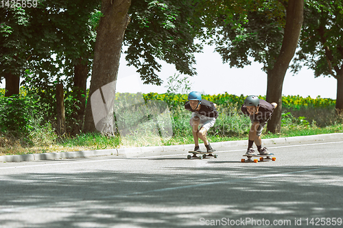 Image of Skateboarders doing a trick at the city\'s street in sunny day