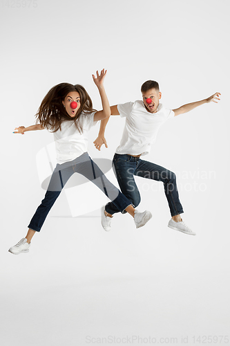 Image of Portrait of beautiful couple celebrating red nose day on white studio background