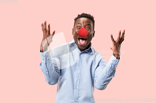Image of Portrait of young african-american man looks crazy happy. Red nose day celebrating