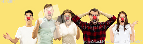 Image of Portrait of beautiful people celebrating red nose day on yellow studio background