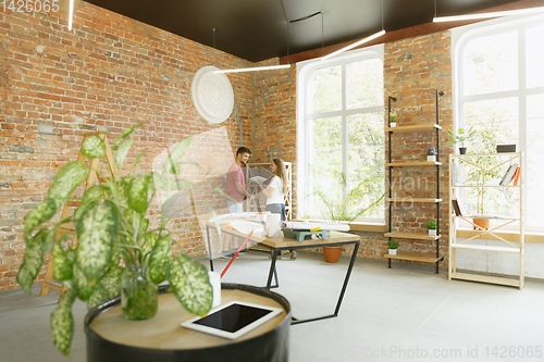 Image of Young couple doing apartment repair together themselves