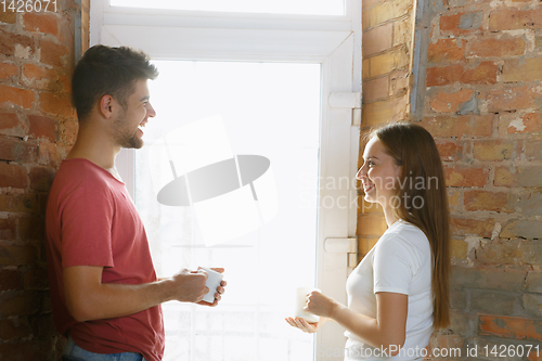 Image of Young couple doing apartment repair together themselves