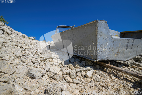 Image of Empty old metal fishing motor boat at shore