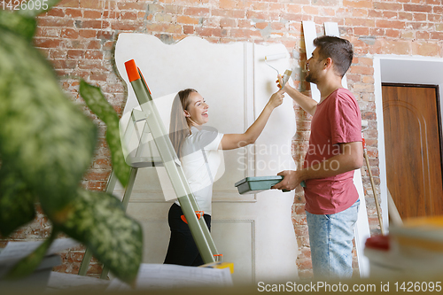 Image of Young couple doing apartment repair together themselves