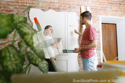 Image of Young couple doing apartment repair together themselves