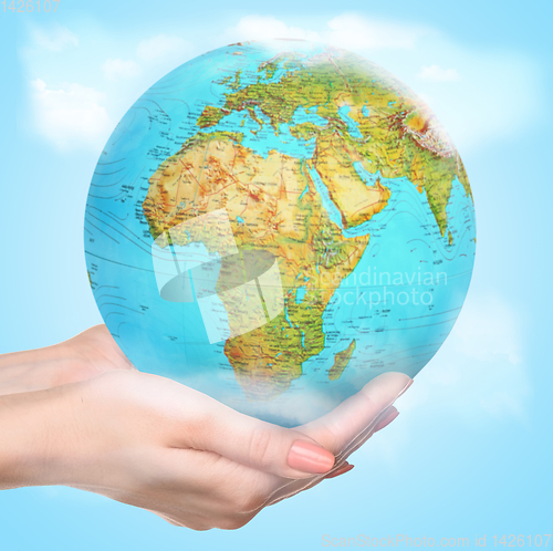 Image of Save the Earth - female hands caressly holding a globe