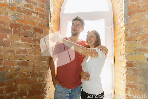 Image of Young couple doing apartment repair together themselves