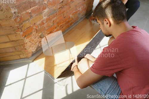 Image of Young couple doing apartment repair together themselves