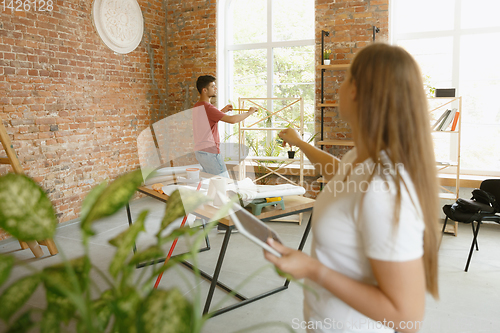 Image of Young couple doing apartment repair together themselves