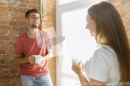 Image of Young couple doing apartment repair together themselves