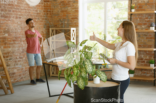 Image of Young couple doing apartment repair together themselves