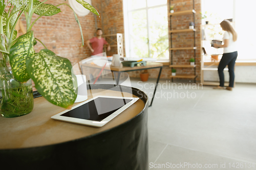 Image of Young couple doing apartment repair together themselves