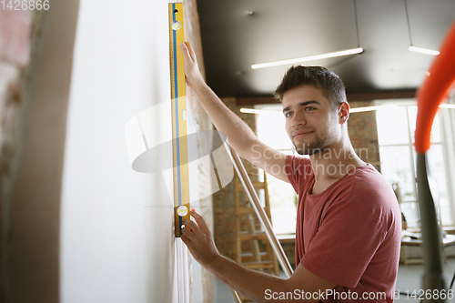 Image of Young man doing apartment repair hisselfes