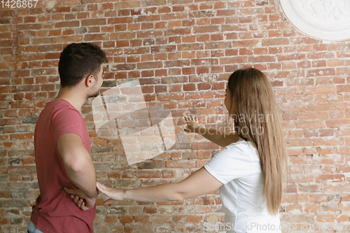 Image of Young couple doing apartment repair together themselves