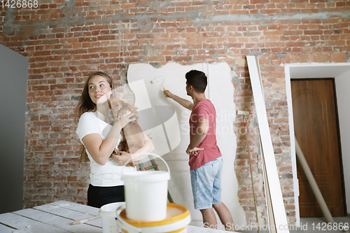 Image of Young couple doing apartment repair together themselves