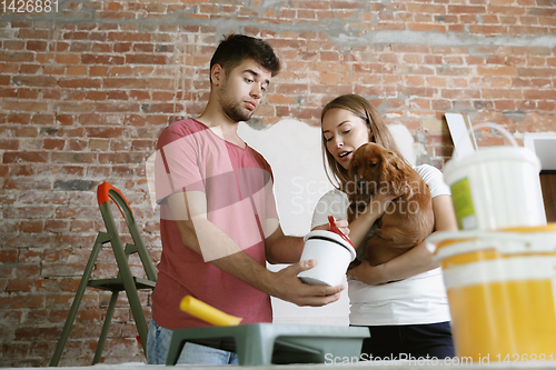 Image of Young couple doing apartment repair together themselves