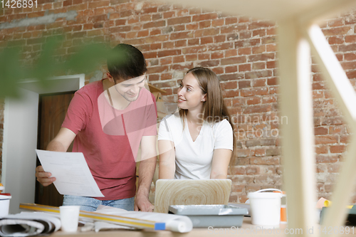 Image of Young couple doing apartment repair together themselves