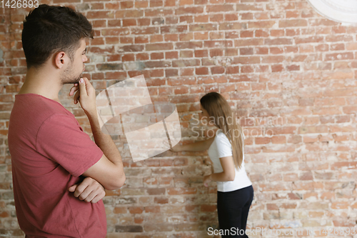 Image of Young couple doing apartment repair together themselves