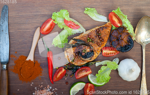 Image of wood fired hoven cooked chicken breast on wood board 