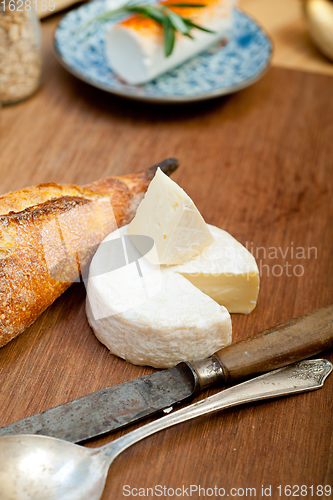 Image of French cheese and fresh  baguette on a wood cutter