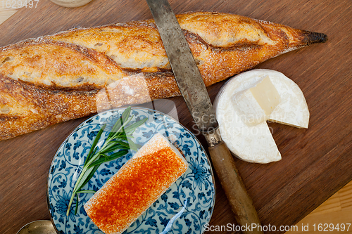 Image of French cheese and fresh  baguette on a wood cutter