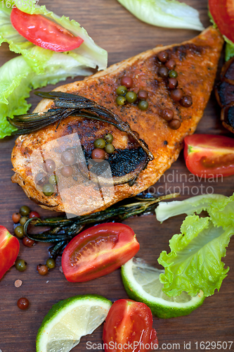 Image of wood fired hoven cooked chicken breast on wood board 