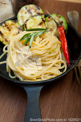 Image of italian spaghetti pasta with zucchini sauce on iron skillet