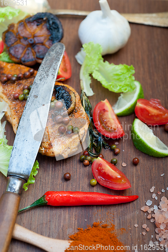 Image of wood fired hoven cooked chicken breast on wood board 