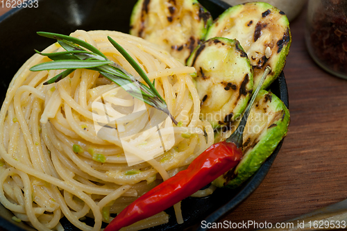 Image of italian spaghetti pasta with zucchini sauce on iron skillet