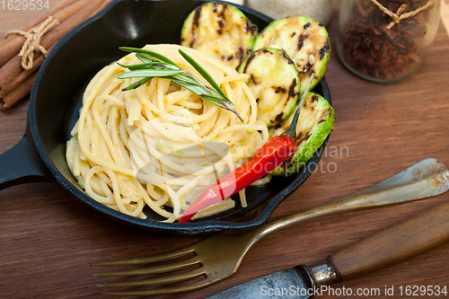 Image of italian spaghetti pasta with zucchini sauce on iron skillet