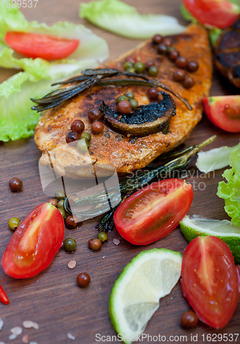 Image of wood fired hoven cooked chicken breast on wood board 