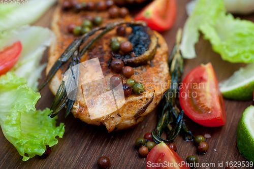 Image of wood fired hoven cooked chicken breast on wood board 