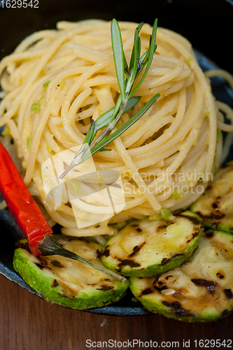 Image of italian spaghetti pasta with zucchini sauce on iron skillet