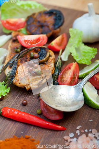 Image of wood fired hoven cooked chicken breast on wood board 