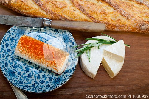 Image of French cheese and fresh  baguette on a wood cutter