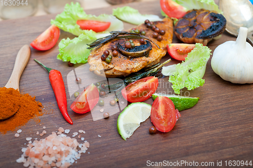 Image of wood fired hoven cooked chicken breast on wood board 