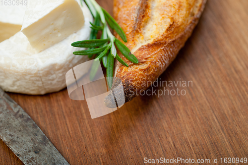 Image of French cheese and fresh  baguette on a wood cutter