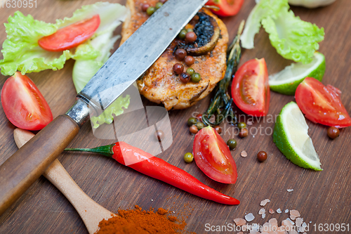 Image of wood fired hoven cooked chicken breast on wood board 
