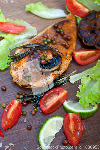 Image of wood fired hoven cooked chicken breast on wood board 