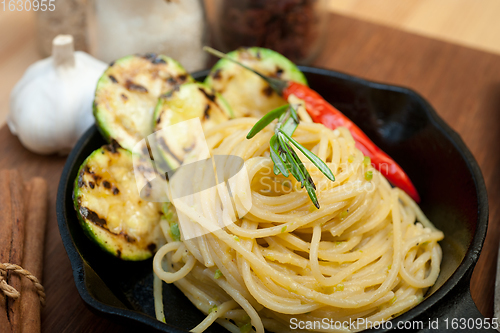 Image of italian spaghetti pasta with zucchini sauce on iron skillet